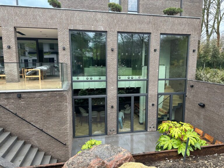 Achterzijde van moderne villa met grote glaspartij