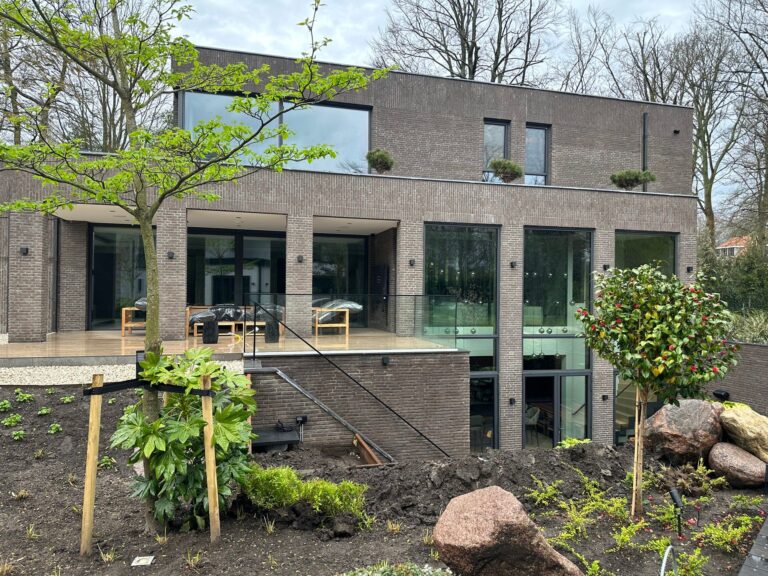Achtergevel van moderne villa met aangelegde tuin